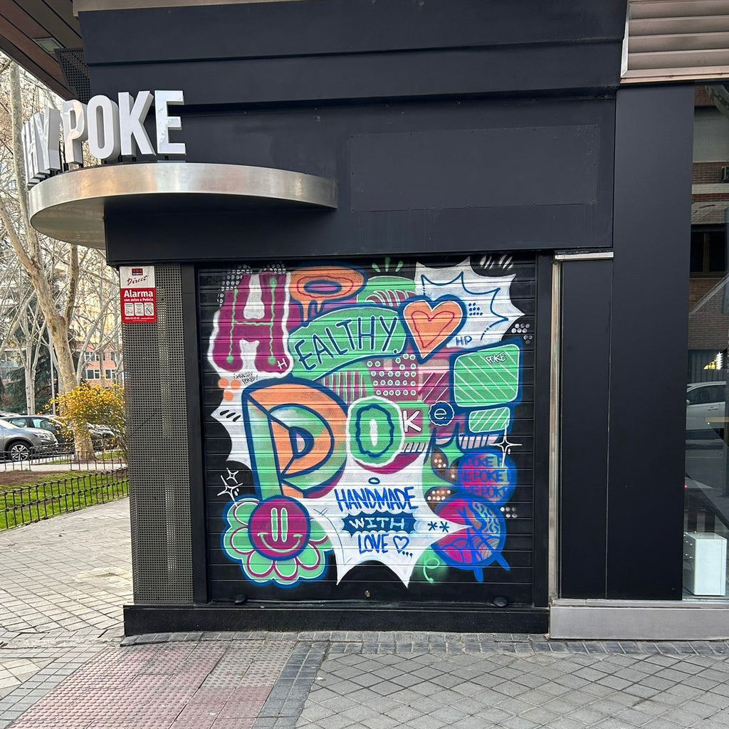 Detalle de diseño graffiti en persiana comercial. Logotipo Healthy Poke con colores pasteles y neón, carita sonriente y tipografía creativa.