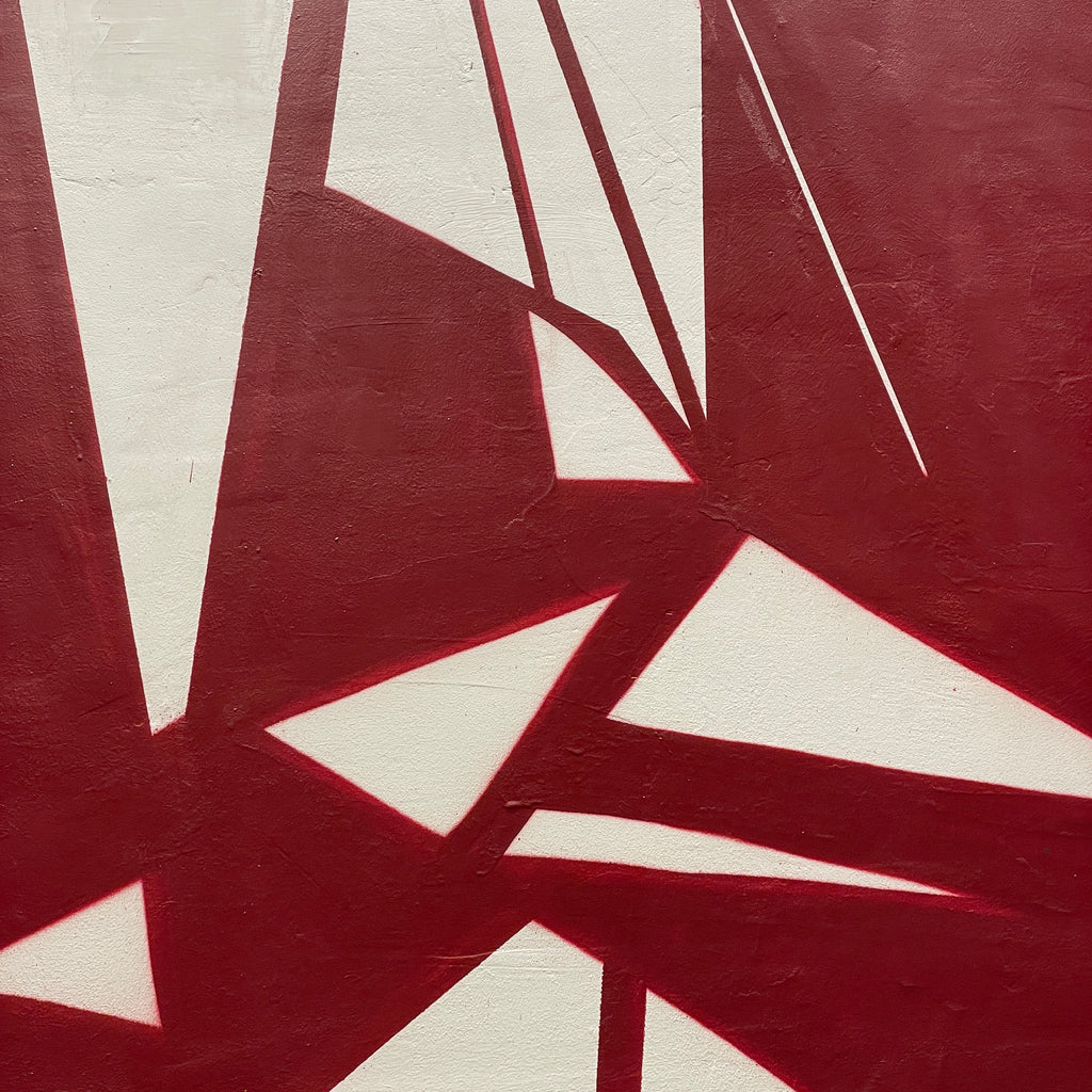 Sección de mural escolar mostrando formas abstractas, pentagramas y líneas geométricas en rojo sobre blanco.