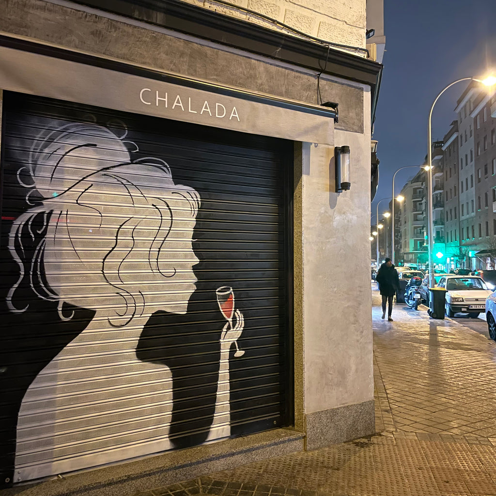 Decoración de fachada comercial en esquina para alta visibilidad desde el coche. Mural de silueta femenina con detalles en rojo vino.