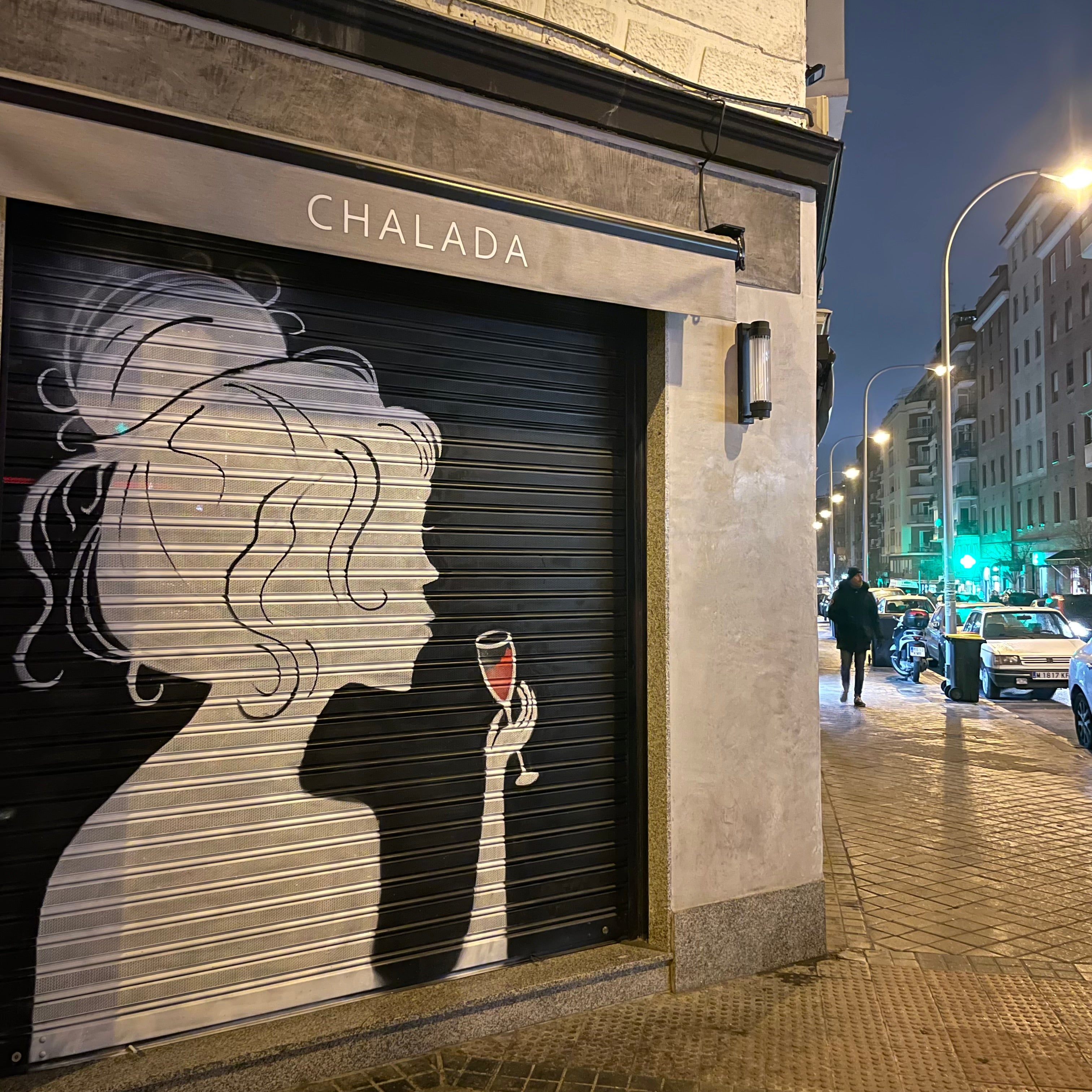 Decoración de fachada comercial en esquina para alta visibilidad desde el coche. Mural de silueta femenina con detalles en rojo vino.