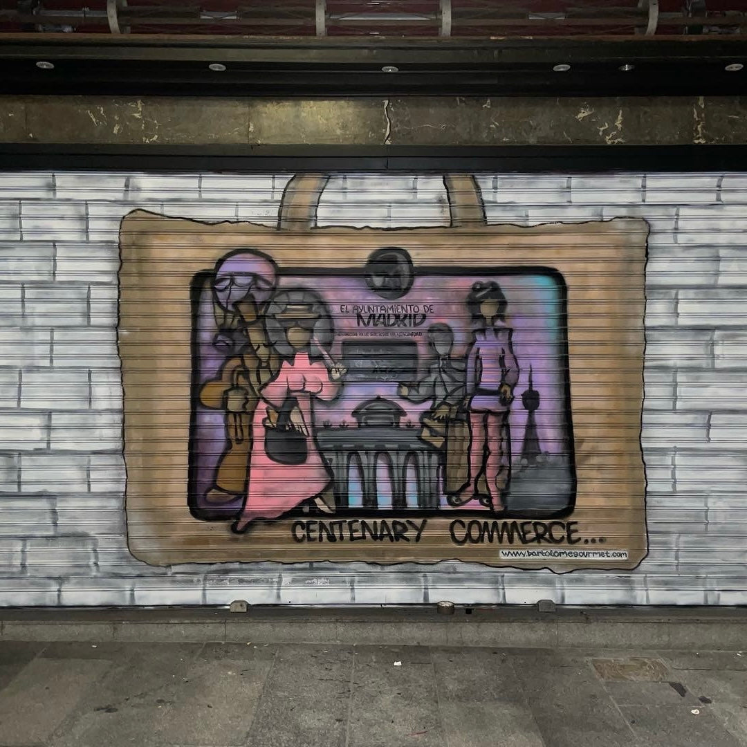 Cierre metálico de Jamonería Bartolomé pintado con mural artístico. Diseño de bolsa de compra con ilustración de placa de comercio centenario de Madrid.