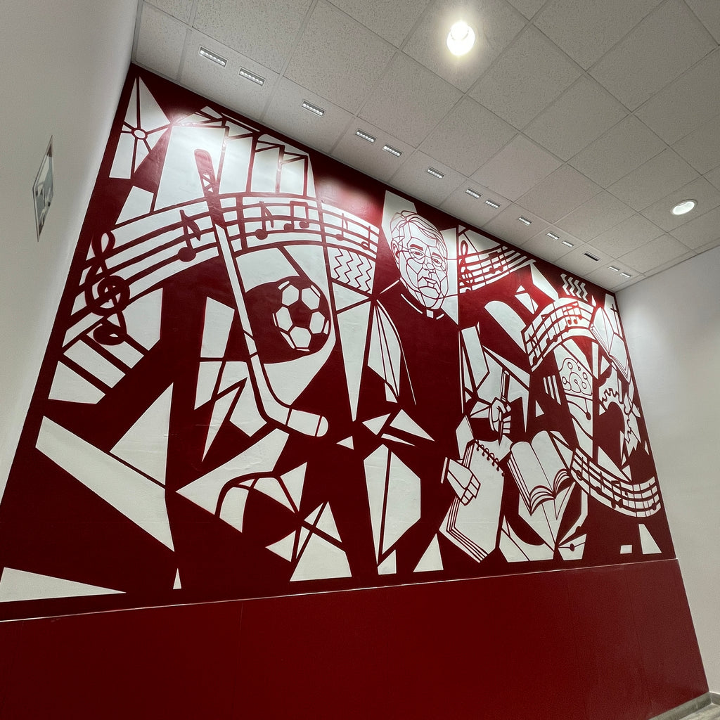Mural interior en colegio color granate y blanco. Diseño geométrico estilo Guernica con figura de D. Luis rodeado de símbolos educativos.
