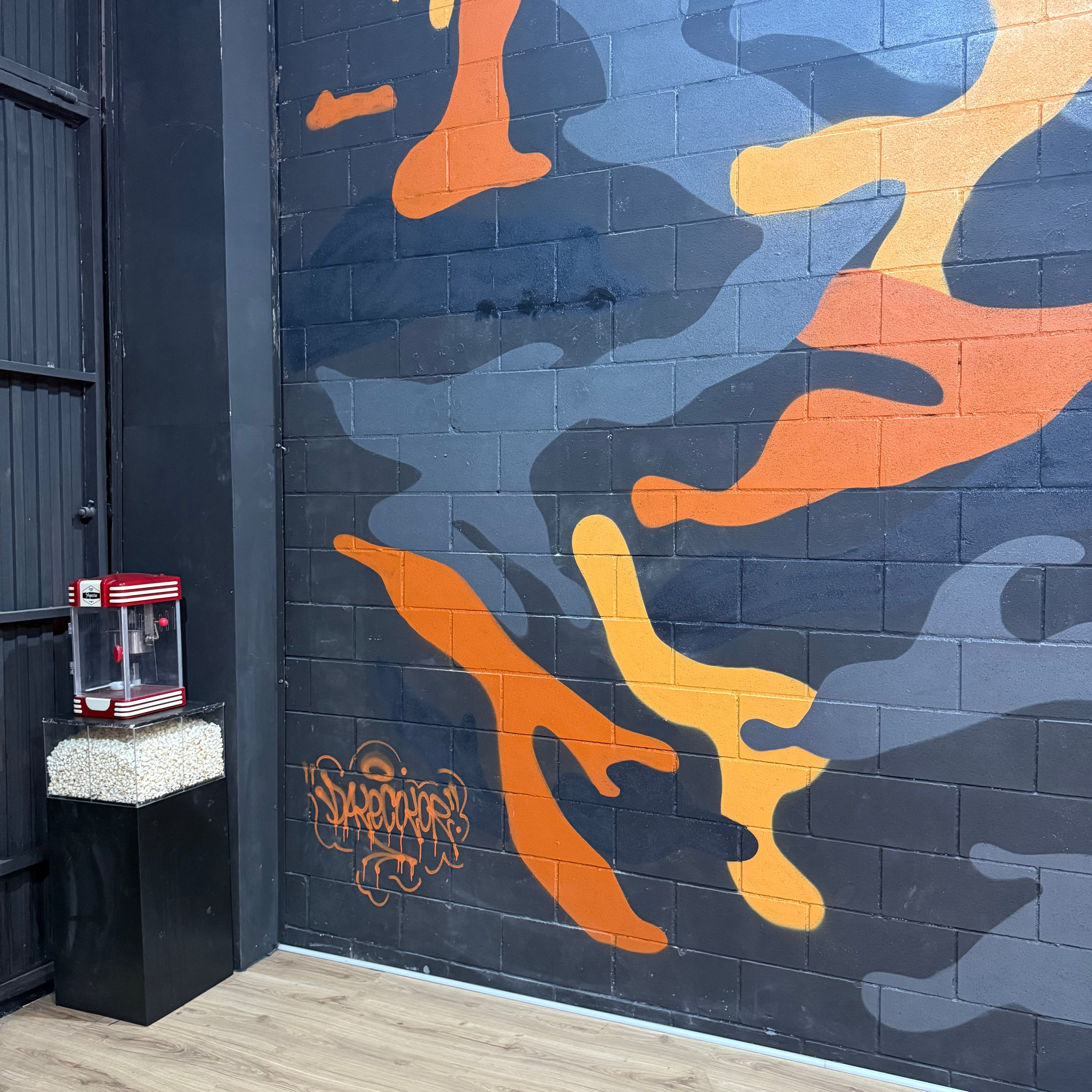 Servicio de murales a domicilio en Madrid. Zona de descanso en estudio de música decorada con graffiti de camuflaje y logotipo corporativo pintado a mano.